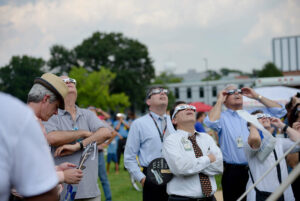 People viewing a solar eclipse wearing safety glasses.
